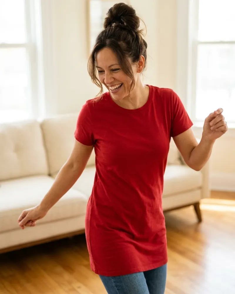 Woman in a red dress dancing in her sunny living room